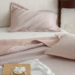 Nahaufnahme des rosa gesteppten Baumwollbettages mit weicher Textur und feinen Nähten.