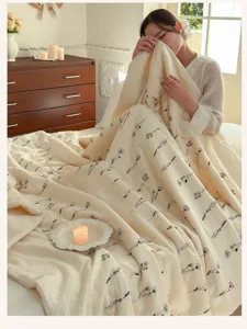 Cozy cotton summer quilt detail, soft beige fabric with delicate black floral print.