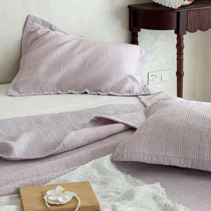 Gesteppte Baumwollbettagesdetail, weicher Washed-Stoff, elegantes helllila Schlafzimmer-Design.