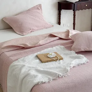Nahaufnahme des weichen rosa gesteppten Baumwollbettüberzugs mit feiner Steppstruktur.