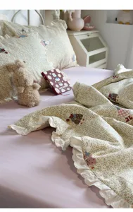 Gezellig bloemig beddengoed detail met delicate kanten volants en zacht katoenen materiaal.
