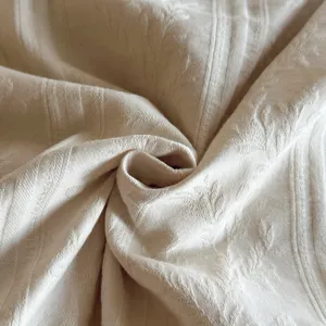 Close-up detail of luxury vintage cotton jacquard bedding fabric with elegant textured pattern.