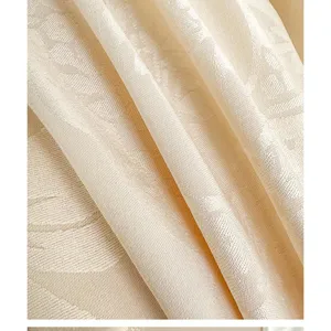 Close-up view of delicate jacquard fabric texture, soft drape and elegant light color design.