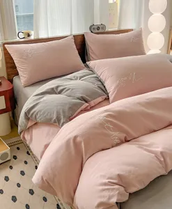 Gezellig 4-delig beddengoed van geruwde katoen met elegante borduursels in roze en grijs.