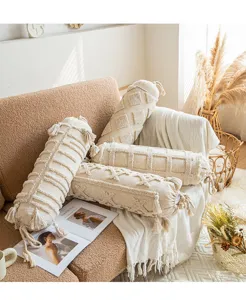 Cylindrical bolster pillow with tufted texture and tassels, decorative sofa cushion for home.