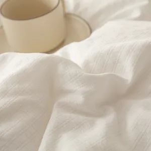 Close-up van het detail van de witte sojavezel dekbedstof met minimalistisch koffiekopje.