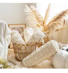 Beige cylindrical decorative throw pillow with bohemian tufted bolster design for sofa