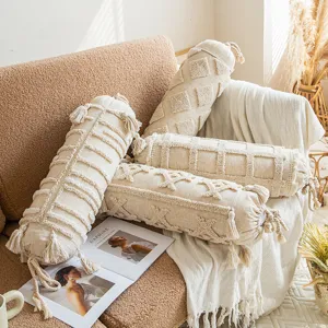 Boho cylindrical throw pillow with textured tufting and tassels, perfect for sofa and home decor.