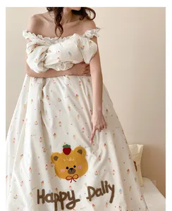 Gros plan de la couette d'été avec broderie d'ours, tissu doux et respirant pour le confort.