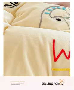 Close-up detail of cream yellow plush fleece bedding fabric with cute cartoon towel embroidery.