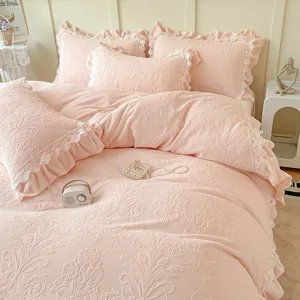 Vista detallada del juego de cama de terciopelo de leche rosa con elegantes encajes.
