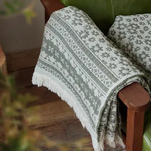 Detailed close-up view of the vintage woven cotton throw blanket showcasing floral patterns.
