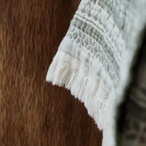 Close-up view of the vintage cotton jacquard throw blanket showcasing fine fringe and texture.