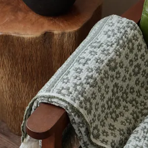 Retro jacquard throw blanket close-up, pure cotton green floral pattern for cozy sofa use.