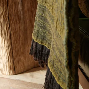 Close-up of vintage cotton jacquard throw blanket with fringe, cozy texture for sofa.