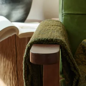 Cotton jacquard throw blanket detail showing vintage green texture and soft fringe edge.