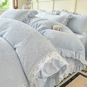 Detalle de ropa de cama de terciopelo de leche repujado, funda nórdica azul con encaje.