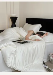 Detailed view of luxury white jacquard tencel quilt in a cozy bedroom, soft texture.