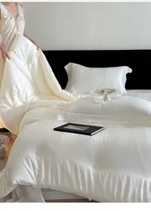 Detailed view of white jacquard soybean quilt and pillowcase set in cozy bedroom scene.