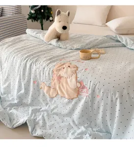 Detailed view of soft washed cotton summer quilt with cute cat embroidery and polka dot design.