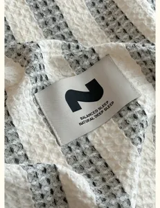 Waffelpiqué Bettwäsche Stoff Detail, hochwertige schwarz weiße gestreifte Baumwollbettwäsche Nahaufnahme.
