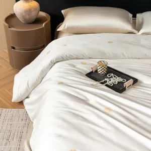 Luxury silk duvet cover set with elegant gold embroidered motifs, soft and comfortable bedding.