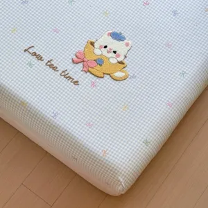 Blue checkered fitted sheet featuring cute cat embroidery, soft cotton mattress cover main view.