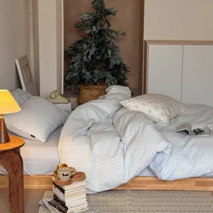 Gedetailleerd overzicht van zuiver katoenen gestreept beddengoed in een gezellige slaapkamer.