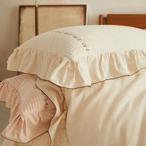 Parure de lit douillette en coton et lin avec broderie florale et volants pour la chambre.