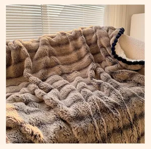 Cozy faux fur blanket with pom pom trim, soft wavy plush throw for couch bed luxury decor.