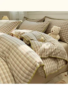 Vista detallada del acogedor juego de ropa de cama de algodón a cuadros con costuras.