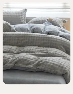 Dettaglio biancheria letto pile goffrato grigio, primo piano copripiumino morbido e spesso.