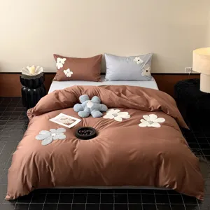 Detailed shot of the brown and blue long-staple cotton bedding set with floral embroidery.