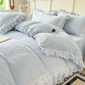 Juego de cama de felpa gofrada azul claro con ribete de encaje blanco para dormitorio acogedor.