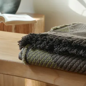 Close-up detail of the woven cotton throw blanket texture and vintage geometric pattern with fringe.