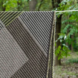 Detailed view of vintage cotton jacquard throw blanket with geometric stripes and stylish fringe.