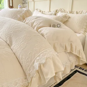 Juego de ropa de cama de terciopelo de leche con volantes de encaje y diseño floral en crema.