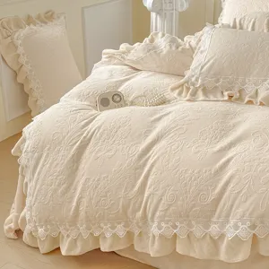 Vista detallada de la lujosa ropa de cama de terciopelo de leche con volantes en la habitación.