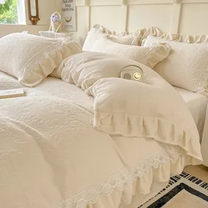 Conjunto de ropa de cama de terciopelo de leche con relieve y volantes, color crema cálido.