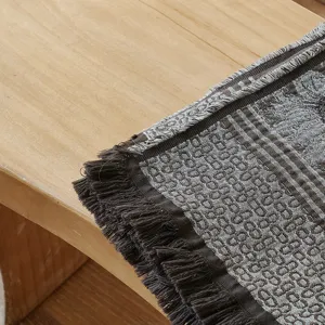 Close-up detail of vintage cotton jacquard throw blanket with stylish fringe and classic pattern.