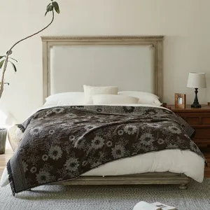 Detail shot of vintage cotton jacquard throw blanket with fringe, cozy bedroom scene decor.