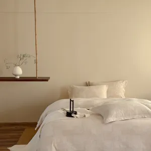 Wabi-sabi style minimalist bedroom bed linen detail showing soft jacquard texture and natural tone.