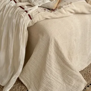 French vintage cotton linen bedding detail shot, delicate floral print and lace trim texture.