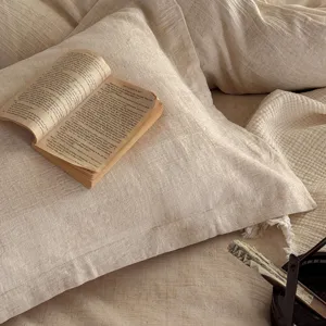 Detailed close-up of textured linen bedding in neutral beige, cozy wabi-sabi bedroom decor.