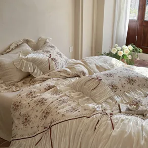 French vintage floral bedding detail shot, showing delicate ruffles and ribbon bow ties.
