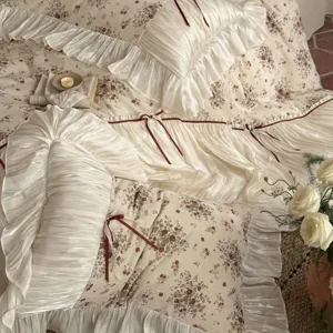 Exquisite vintage floral bedding detail showcasing romantic ruffles and delicate bows on soft fabric.