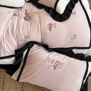 Detailansicht der kuscheligen Winter-Bettwäsche mit schwarzen Rüschen und zarten Rosen-Stickereien.