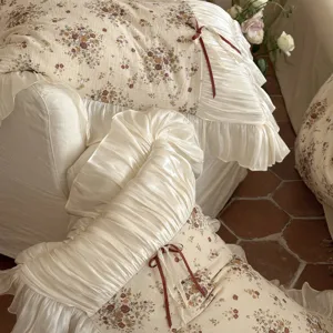 French vintage floral cotton linen bedding detail, ruffles and ribbon bow decoration.