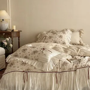 Detail shot of French vintage floral cotton-linen bedding featuring romantic bow and lace trim.