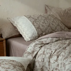 Detailed view of French vintage floral bedding with delicate lace trim, soft cotton fabric.